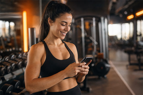 Atleta utilizando smartphone para acompanhar treino na academia